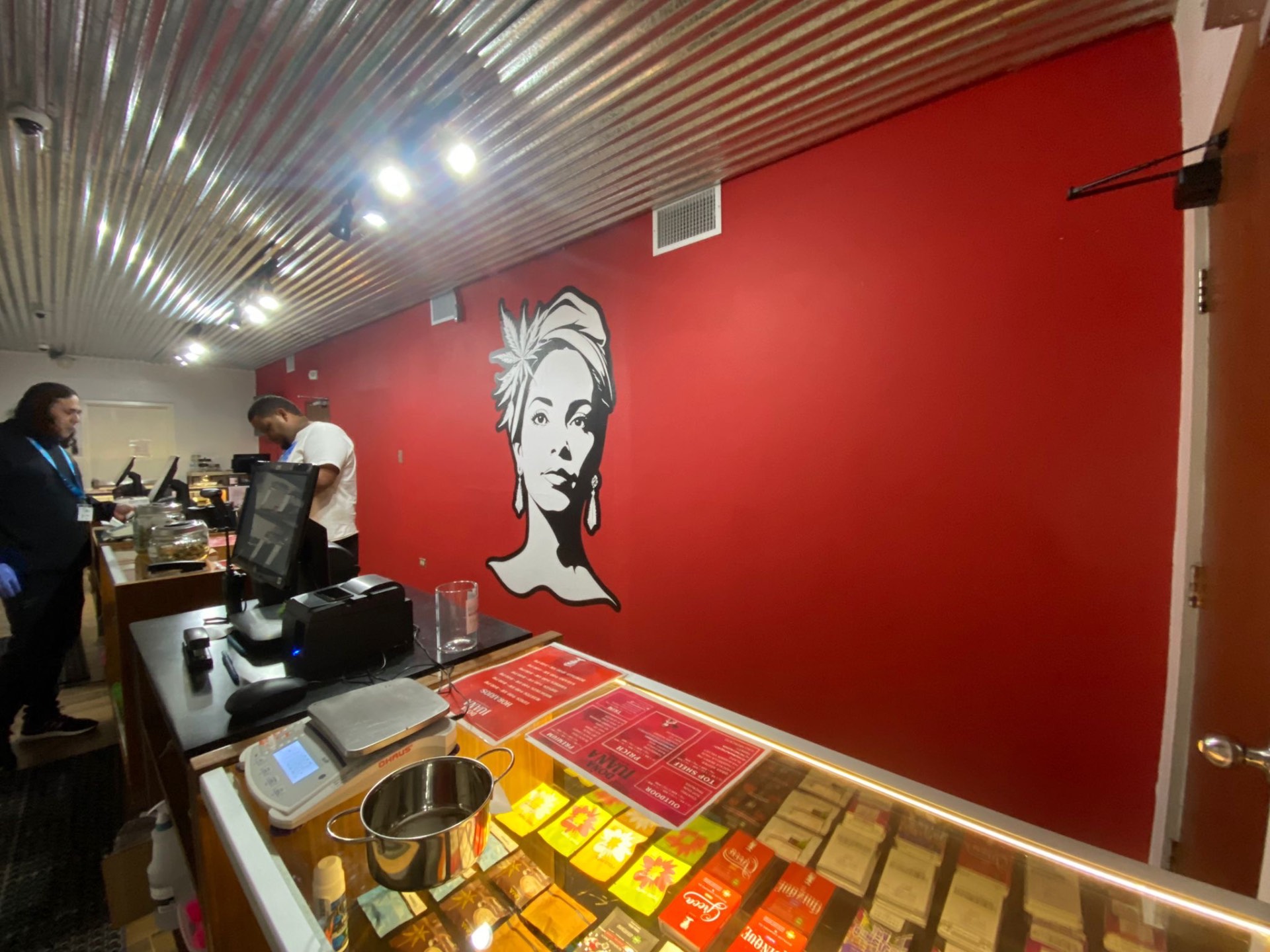 Mural de Doña Juana en pared roja del dispensario